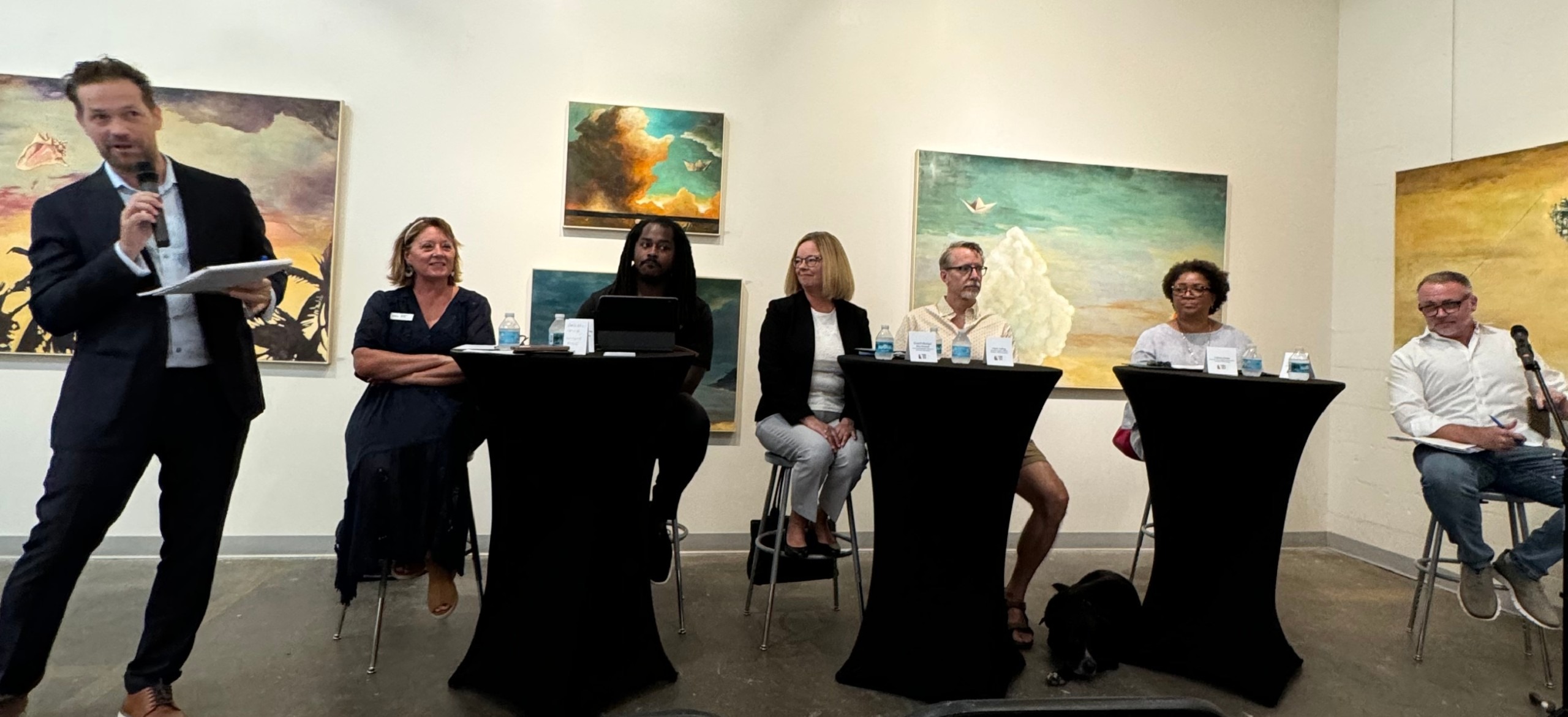 A panel of people at tables.