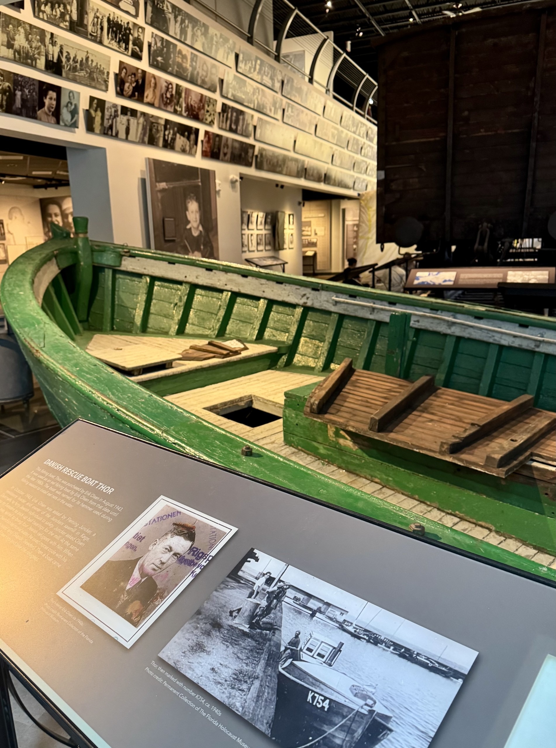 A green boat on display in a museum.