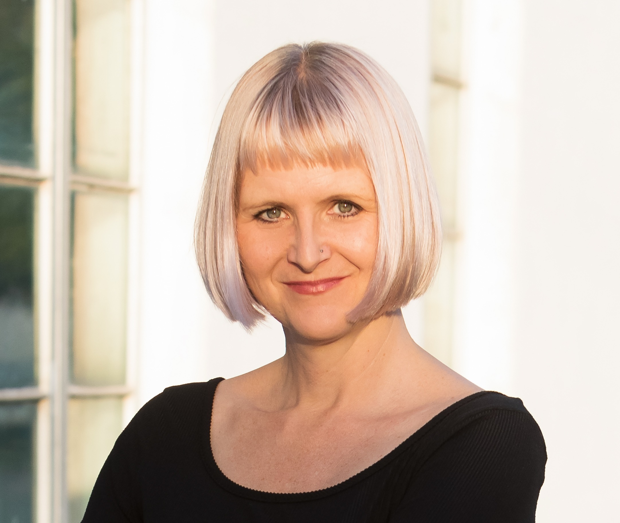 A woman with a blonde bog poses.