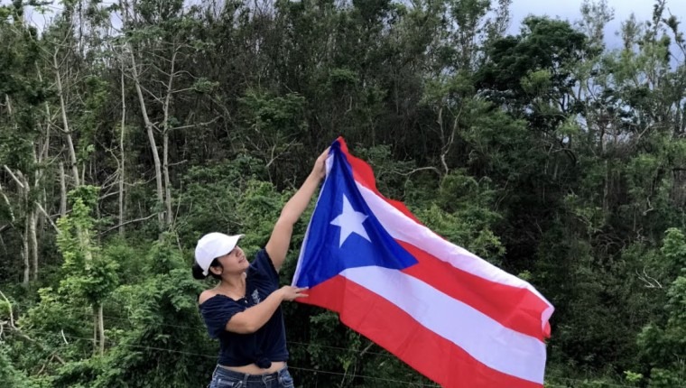 Artist holding up a Puerto Rican flag