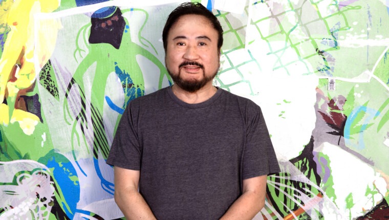 A man poses with a colorful background.