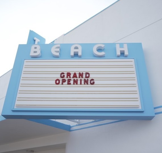 A theater's marquis reads Grand Opening.