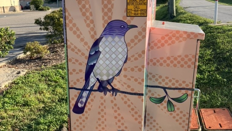 A signal box is decorated with a bird.