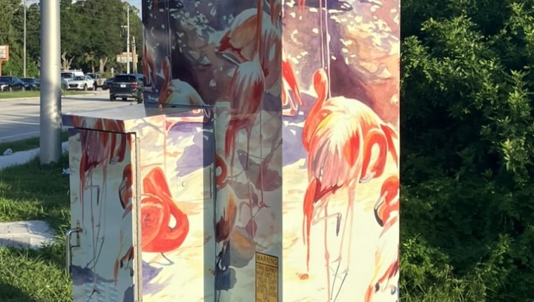 A signal box is decorated with flamingos.