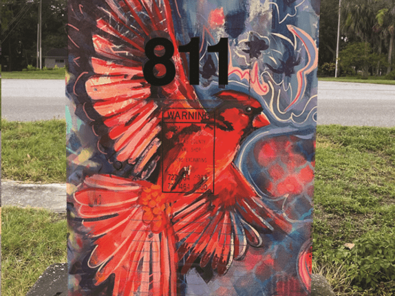 A signal box is decorated with a red bird.