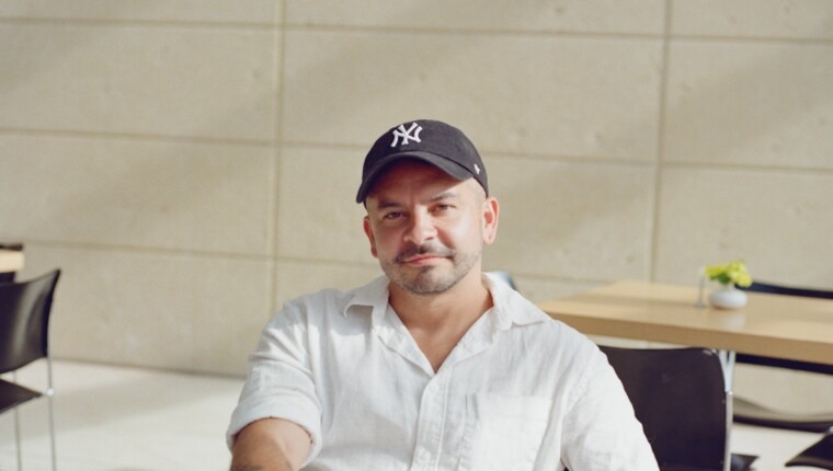 A man in a cap sits at a table.
